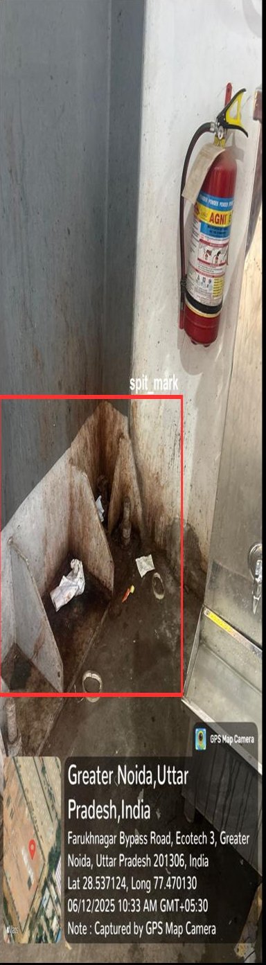 Warehouse corner with stains and a spit mark outlined by the VICAS vision system beside a fire extinguisher