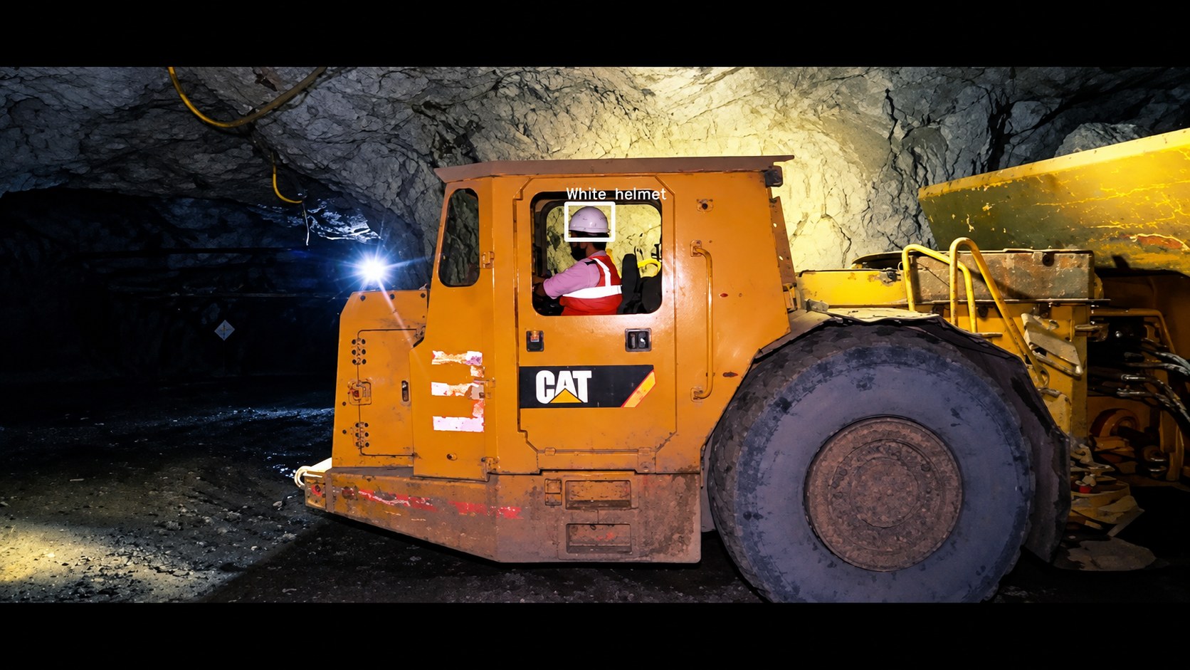 Detection view of a loader operator wearing a white helmet inside the cab
