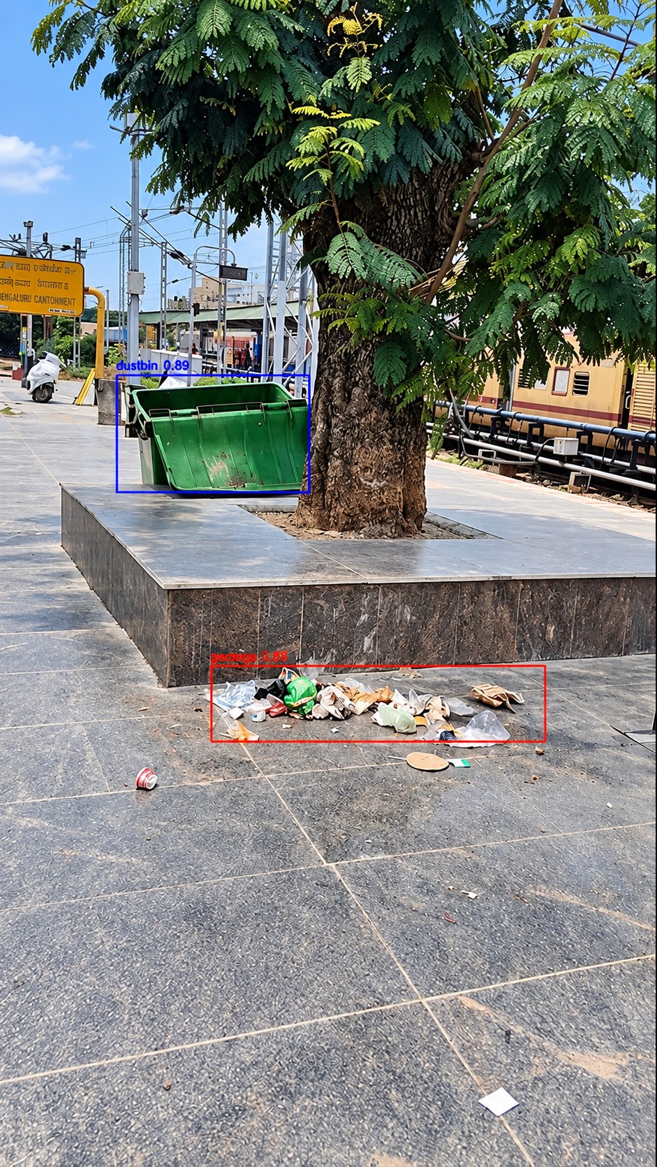 Pile of loose garbage on a station concourse detected and boxed, beside an overflowing dustbin