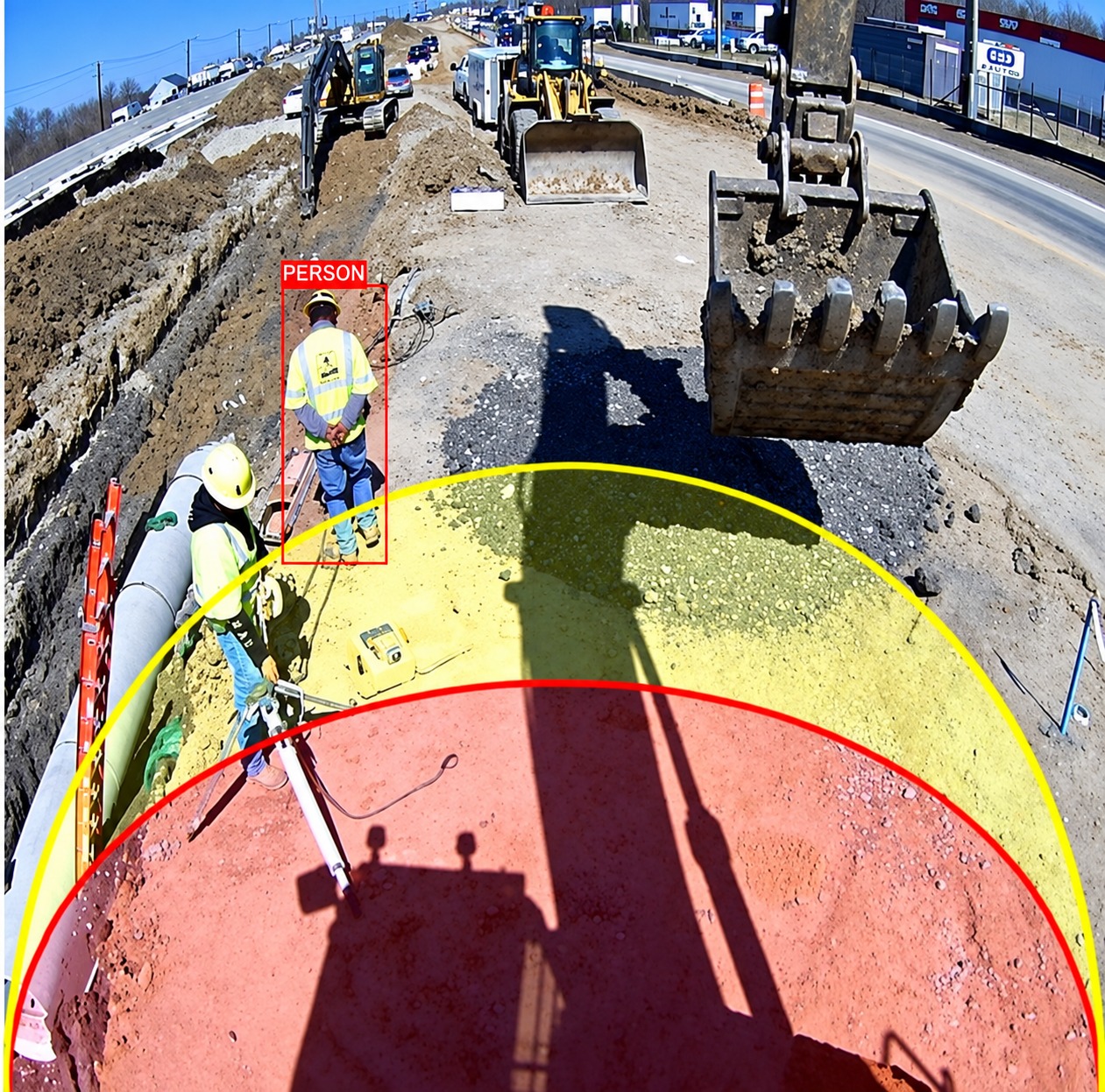 Excavator camera view with red danger zone and yellow warning zone projected on the ground, a worker detected at the edge